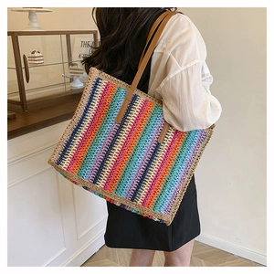 Close-up of rainbow striped straw tote bag with brown faux leather shoulder straps