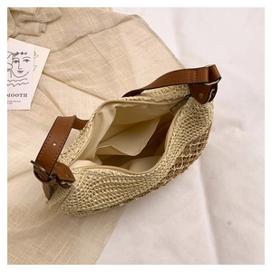 Detail view of woven straw tote bag with brown leather strap and canvas lining structure