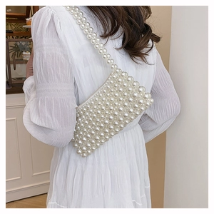 Close-up of elegant handmade white pearl woven handbag with a long beaded shoulder strap