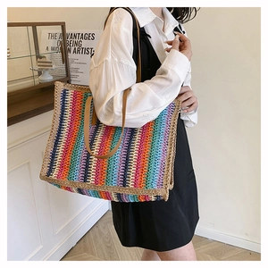Detail of colorful rainbow woven straw tote bag with brown faux leather handles for summer