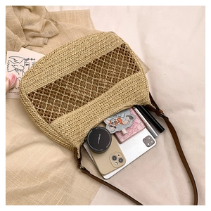 Close-up of handmade straw shoulder bag showing spacious interior for essentials