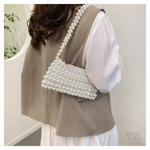 Detailed view of handmade cream pearl woven handbag with silver metal zipper closure