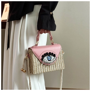 Détail du rabat en cuir rose avec broderie œil de protection sur sac en paille
