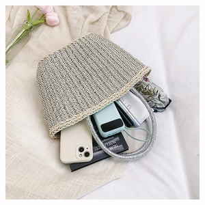 Top view of handmade woven straw bucket bag showing interior storage and daily essentials