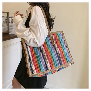 Detailed texture of colorful striped straw tote bag with brown leather shoulder straps