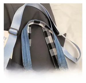 Close-up of adjustable woven strap and vintage metal buckle on blue denim tote bag