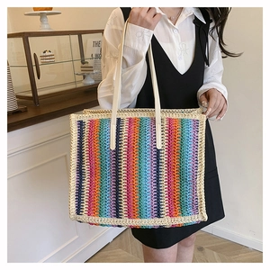 Detail of colorful woven tote bag with white shoulder straps in a cafe setting