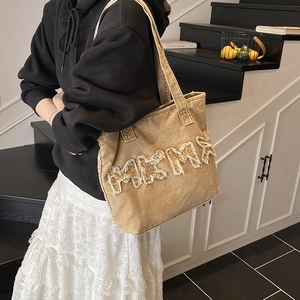 Retro denim tote bag with oversized frayed lettering and casual shoulder strap