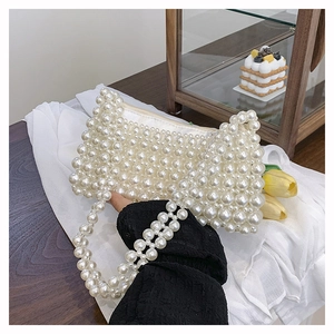 Close-up of handmade beaded square handbag featuring cream pearls and zipper closure
