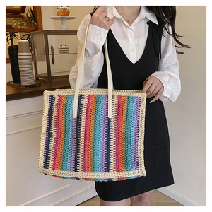 Rainbow striped woven tote bag with cream leather handles in a cozy cafe setting