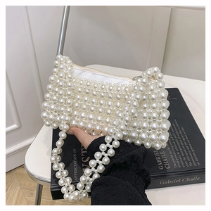 Detail of white handmade faux pearl beaded mini bag with top zipper and double handles