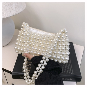 Macro detail of white pearl beaded handbag with silver zipper closure and lining