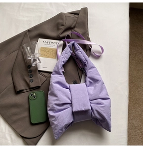 Detailed close-up of a purple quilted bow tote bag styled with elegant fashion items