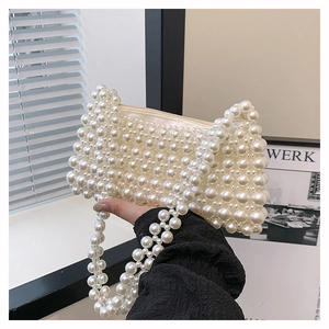 Close-up of handmade cream pearl woven handbag showing the zipper and bead texture