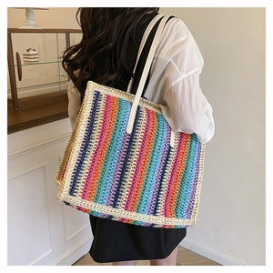 Close-up of a colorful crochet tote bag featuring vibrant stripes and white shoulder straps
