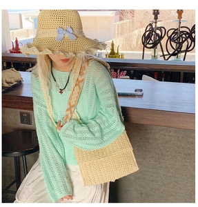 Detail of straw crossbody bag and sun hat with blue bow during casual summer travel