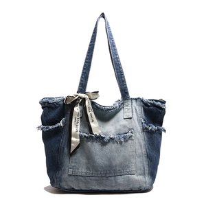 Vintage washed denim tote bag with frayed edges and decorative silk scarf on white background