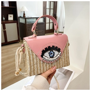 Détail du rabat en cuir rose et sac en paille avec œil pailleté et accents de franges