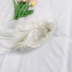 Detail of beaded pearl bag showing metal zipper closure and smooth white satin lining
