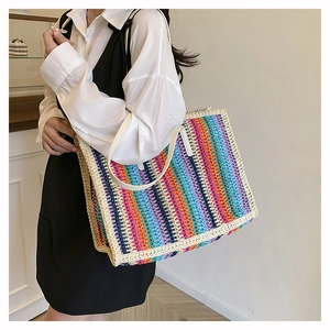 Detail of the colorful rainbow crochet knit pattern on a large straw tote bag