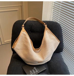 Λεπτομέρεια υφής από ψάθινη τσάντα με καφέ δερμάτινη επένδυση σε βελούδινη καρέκλα