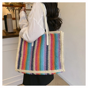 Detail of colorful woven tote bag with vertical stripes and white leather shoulder straps