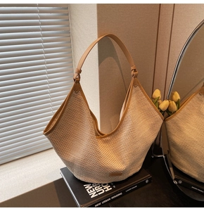 Λεπτομέρεια ψάθινης τσάντας με καφέ δερμάτινη επένδυση και υφαντή υφή