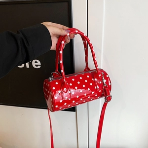 Red and white polka dot barrel handbag with adjustable strap for a retro chic look