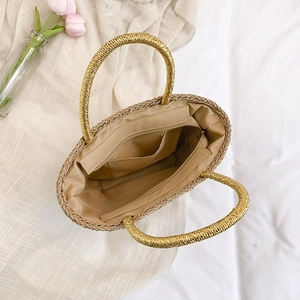 Handwoven straw beach tote bag with gold-wrapped handles and zipper closure