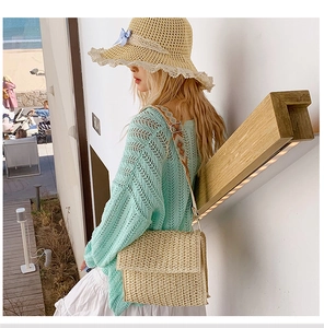 Detail of hand-woven straw bag with colorful geometric strap for summer travel outfits