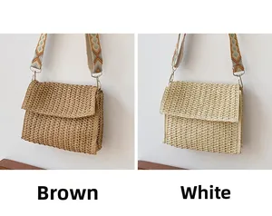 Detail view of woven straw shoulder bags in brown and white with ethnic geometric straps