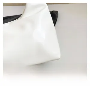 Close-up of premium white faux leather texture with fine stitching on shoulder bag