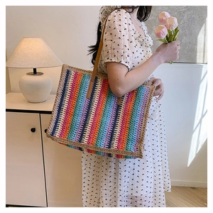 Detail of colorful rainbow woven tote bag featuring soft crochet texture and leather handles