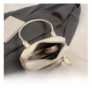 Internal capacity of the beige rivet pillow bag showing storage for cosmetics and essentials