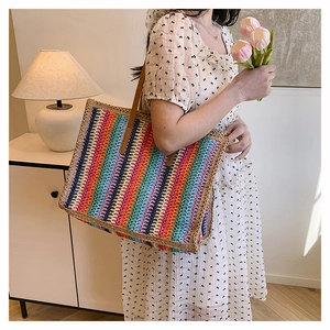 Detailed texture of a large colorful hand-woven beach tote bag with brown leather straps