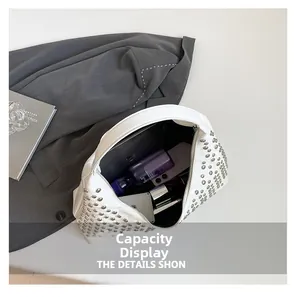 Detail view showing large interior capacity of the white studded bucket bag with tablet and items