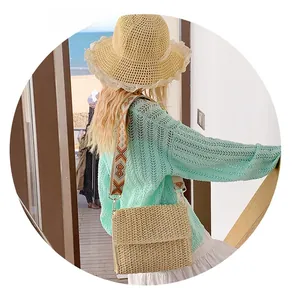 Detail of beige straw bag with geometric embroidery strap for casual summer vacations