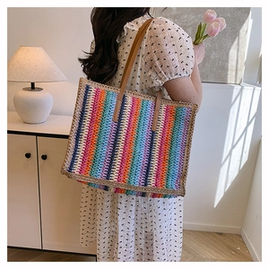 Detail shot of multi-color striped woven tote bag with brown leather handles and natural texture