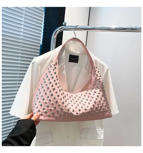 Detail of pink hobo bag featuring silver metal rivets and soft leather texture