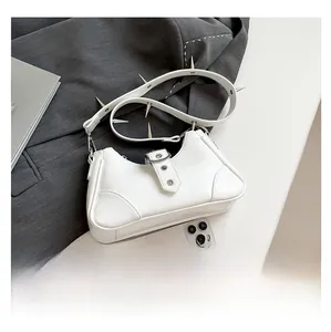 Détail du sac blanc à rivets argentés avec smartphone pour comparer l'échelle de taille