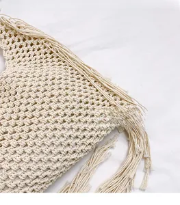 Macro view of handmade woven cotton bag showing hollow geometric patterns and fringe detail