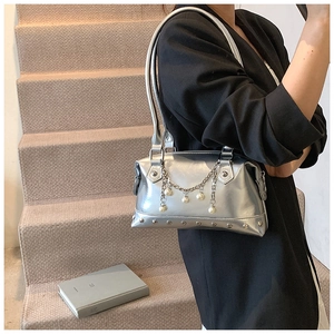 Detailansicht der silbernen Kissen-Tasche mit Perlenkette und Metallnieten-Dekor
