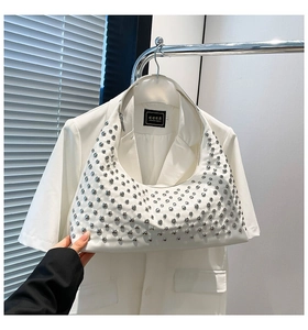 Detail of silver rivets on a white crescent hobo bag with sleek synthetic leather finish