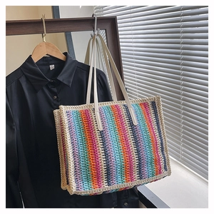 Detail of multi-color striped straw woven tote bag with premium leather handles