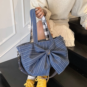 Large dark blue denim tote bag with striped bow detail and adjustable shoulder strap