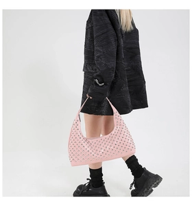 Detail of pink patent leather moon bag with silver rivets and street style aesthetic