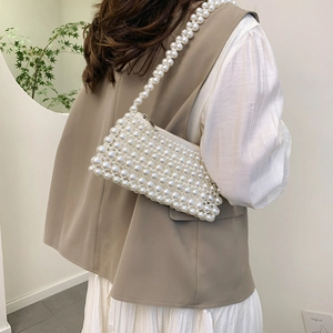 Elegant white handmade beaded pearl shoulder bag with top zipper on a female model