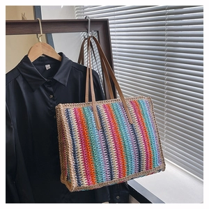 Macro detail of multi-color rainbow weave and brown faux leather handle on summer tote bag