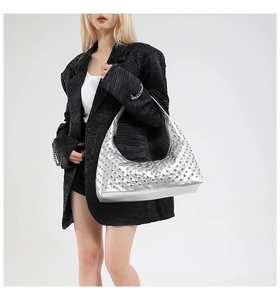 Silver metallic hobo bag with polished rivets shown on a black textured blazer outfit