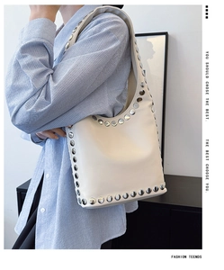 Detailaufnahme der silbernen Nieten an einer cremeweißen Hobo-Schultertasche für Damen